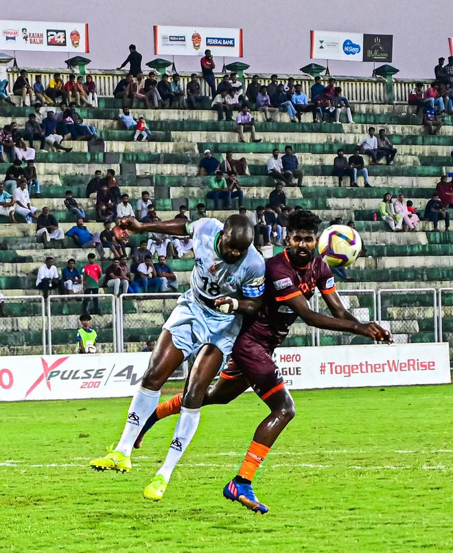Gokulam striker Shijin (right) and NEROCA captain David Simbo engage in a mid-air tussle.